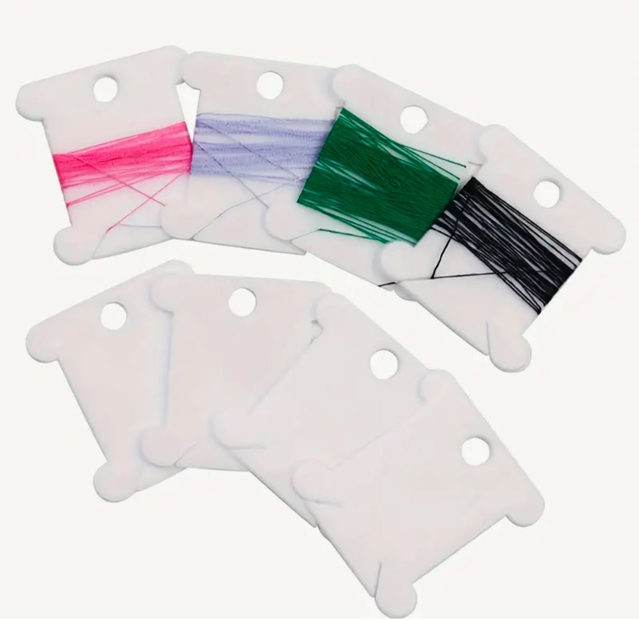 White plastic thread bobbins - Threading Carefully